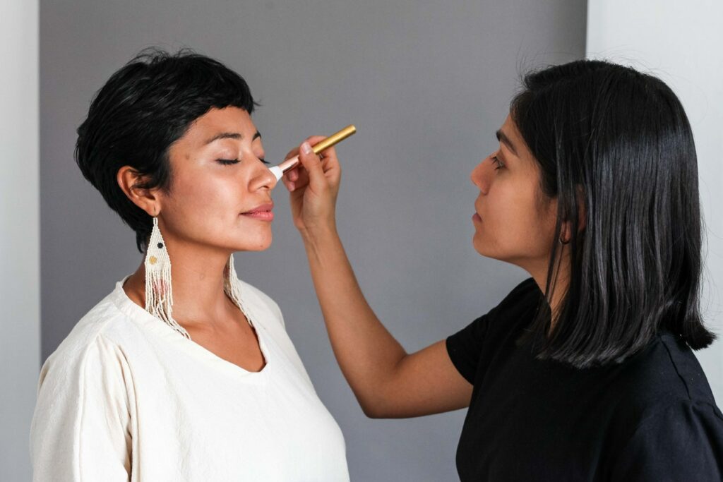 Makeup artist applying makeup to her female client